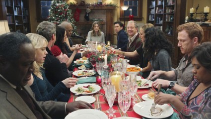 Meredith, Derek, and their guests gather around the table for Christmas dinner.